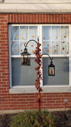 a red brick building with two windows and a lamp post in front of the window