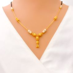 This exquisite 22k gold Mangal Sutra, weighing 11.8 grams, showcases an opulent two-tone design, blending the richness of yellow and white gold. The classic black beads add contrast to the 18-inch necklace, which features a 1-inch drop for added elegance. Secured with a hook lock, this piece offers both comfort and style. Ideal for those who appreciate luxurious craftsmanship, the two-tone finish gives this Mangal Sutra a modern twist while retaining its traditional essence. Perfect for making a statement on special occasions or as a standout daily piece. PRODUCT DETAILS Gold Purity(karat): 22k Item Weight(grams): 11.8 Item Finish: Yellow + White Gold Stone: Black Bead Necklace Length: 18" Drop Length: 1" Lock Style: Hook Lock 22k Gold Dual-tone Necklace Gift, Dual-tone 22k Gold Necklace For Gifts, Dual-tone Yellow Gold Necklace For Festivals, Yellow Gold Dual-tone Necklace For Festivals, Dual-tone Yellow Gold Temple Jewelry Necklace, Yellow Gold Dual-tone Temple Jewelry Necklaces, Yellow Gold Dual-tone Temple Jewelry Necklace, Gold Pearl Necklace With Black Round Beads, 22k Dual-tone Yellow Gold Necklaces