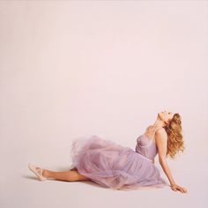 a woman in a purple dress laying on the ground