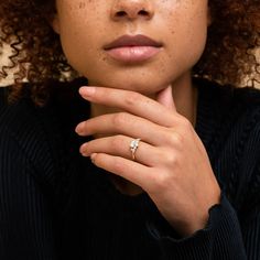 a woman with curly hair wearing a ring