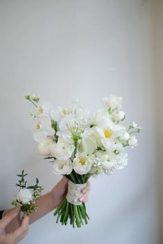 a person holding a bouquet of white flowers