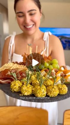 a woman holding a platter with food on it