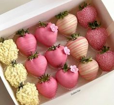 a box filled with lots of pink and white chocolate covered strawberries next to each other