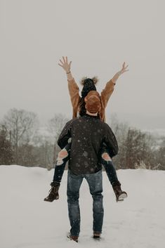 two people are playing in the snow with their hands up and one person is holding his head