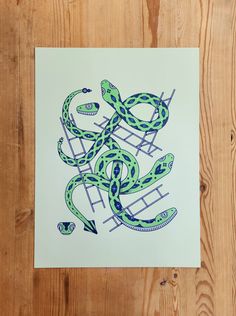 a drawing of a green snake on a white paper with blue and black lines in the middle