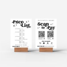 two business cards on wooden stand with price list and scan to pay written in black ink