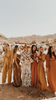 the bridesmaids are dressed in brown and tan dresses for their desert elopement