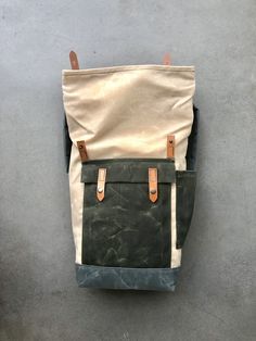 "Medium size backpack made from heavy weight waxed canvas in the color natural with an outside pocket and bottle pocket made in waxed canvas color olive green. Bottom and shoulder straps are made in grey waxed canvas I made it into an everyday backpack/rucksack, with waxed canvas padded straps. Roll to close top, and outside pocket with protective flap. This backpack as a bottle pocket on one side The bag closes with roll to close system and snaps with a vegetable tanned leather strap. This medi Khaki Waxed Canvas Backpack For Outdoor, Everyday Waxed Canvas Backpack With Pockets, Khaki Waxed Canvas Backpack, Khaki Waxed Canvas Standard Backpack, Waxed Canvas Leather Backpack, Hipster Backpack, Waxed Canvas Backpack, Commuter Backpack, Everyday Backpack