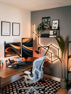 a desk with a chair, computer monitor and keyboard on it in front of a wall