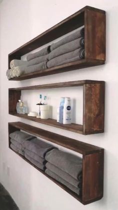 two wooden shelves holding towels and other bathroom items