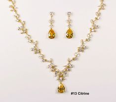 "The default will be: \"Citrine CZ Stone, Kraft/Tan box with twine & no message\". If you need different colored Stone, please check the stone color chart in last photo & specify the color number in checkout notes section. This three pieces jewelry set is made with high quality AAA cubic zirconia on triple white gold plated set. The necklace has 15 CZ sections linked with a Teardrop CZ pendant size of 12 x16mm. Total length is 17-19 inches adjustable. Let me know if you would like customized to Yellow Cubic Zirconia Necklaces For Wedding, Gold Citrine Necklace For Wedding, Elegant Yellow Bridal Necklace For Celebrations, Citrine Jewelry With Matching Earrings For Wedding, Citrine Wedding, Wedding Jewelry Set, Bridal Jewelry Set, Gold Bridal Earrings, Zirconia Necklace