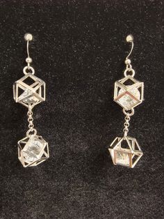 These silver plated geometrically shaped, hollow earrings with faceted glass on the inside are stunning to me. A friend of mine says I make chandeliers and these are the closest I believe I have come so far. They are light since they are mostly just an outline of metal with surgical steel chain running between them. Everything hangs from hypoallergenic silver hooks. Modern Silver Metal Crystal Earrings, Modern Silver Crystal Earrings, Modern Silver Dangle Crystal Earrings, Modern Sterling Silver Dangle Crystal Earrings, Modern Sterling Silver Crystal Earrings In Silver, Silver Faceted Earrings For Party, Silver Faceted Dangle Crystal Earrings, Faceted Dangle Earrings For Party, Faceted Sterling Silver Earrings For Party