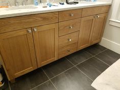 a bathroom with wooden cabinets and tile flooring