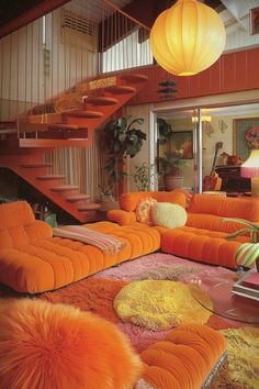 an orange living room with lots of pillows and rugs on the floor next to stairs