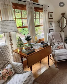 a living room filled with lots of furniture and windows covered in white curtained drapes