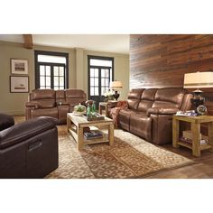 a living room filled with brown furniture and lots of wood flooring on the walls