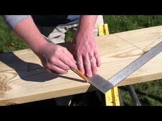 a man is using a pair of scissors to cut a piece of wood on a bench