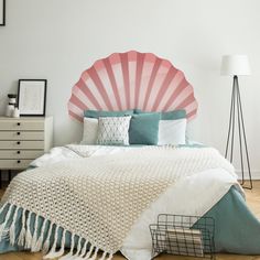 a bedroom with a large pink shell headboard and white bedding on the wooden floor