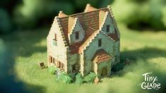 a toy house sitting on top of a lush green field