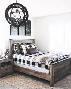 a bed room with a neatly made bed and a chandelier hanging from the ceiling