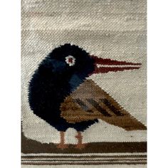 a bird is standing on the edge of a rug