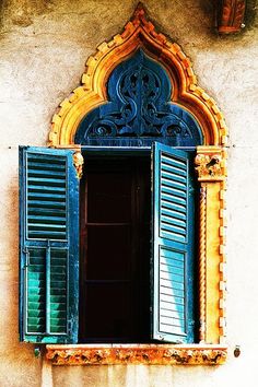 an old window with blue shutters on the outside