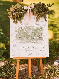 a sign that is on top of a wooden easel in front of some plants