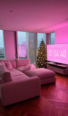 a living room filled with furniture and a christmas tree in front of a large window