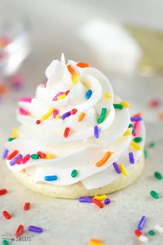 a cupcake with white frosting and sprinkles