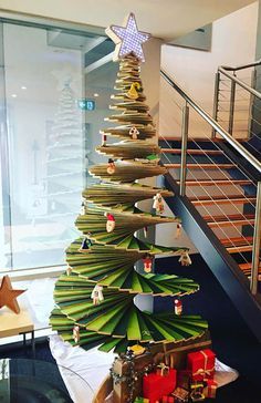 a christmas tree made out of surfboards in front of a stair case and window