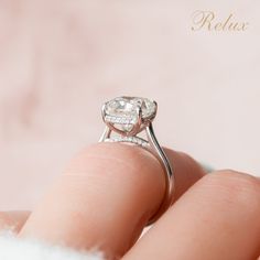 a close up of a person's hand holding a ring with a diamond on it