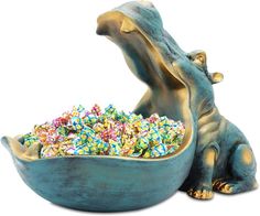 an elephant statue sitting next to a bowl filled with sprinkles