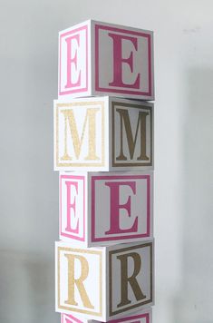 a pink and gold block with the word emer spelled out in different letters on it