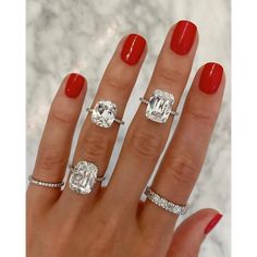 a woman's hand with three different rings on her fingers and two engagement rings