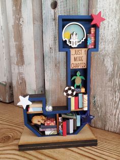 a book shelf with books and magnets in it on a wooden table next to a fence