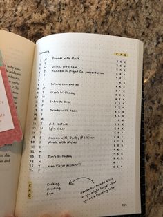 a hand holding an open book with writing on it and a notepad attached to the page