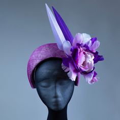 This stunning purple halo headband fascinator is the perfect finishing touch for any occasion. Handcrafted from high-quality materials, it features a purple sinamay base, delicately adorned with feathers, flowers, and a beautiful pearl and crystal centerpiece. The band is covered in a soft, comfortable fabric to ensure a secure and comfortable fit for all-day wear. Whether you're attending a wedding, a day at the races, or a special event, this headband fascinator is sure to turn heads and add a Purple Summer Fascinator For Formal Occasions, Adjustable Purple Headpiece For Evening, Adjustable Purple Headband For Evening, Adjustable Purple Hair Accessories For Summer, Formal Purple Headband Headpiece, Summer Formal Purple Fascinator, Purple Headpiece With Handmade Flowers For Kentucky Derby, Adjustable Purple Fascinator For Summer, Purple Headband With Handmade Flowers