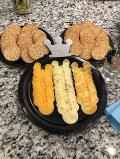 two plates with crackers, bananas and other food items on top of a table