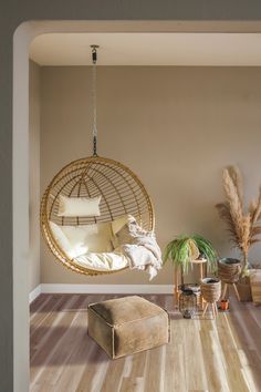 a living room with a hanging chair and other items on the floor in front of it