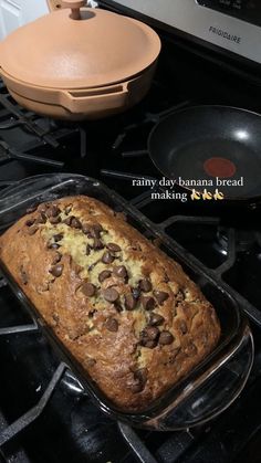 a loaf of bread sitting on top of an oven next to a pan with chocolate chips