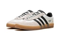 The Bad Bunny x adidas Gazelle Indoor “Off White” is a collaboration on the retro indoor soccer style by the ultra-popular international recording artist.  Bad Bunny and adidas’s partnership began with a bang with the debut of the adidas Forum Buckle Low in 2021.  Since then, the pair has released several high-profile sneakers, including this Gazelle Indoor in versatile “Off White. ” The upper has an Off White leather design with grey hairy suede overlays on the toe and heel.  Oversized black leather Three Stripes branding appears on either side of the shoe, while “adidas” “Benito” stamps can be seen on the lateral side of the mid-panel.  White rope-style laces are layered over the black tongue.  A semi-translucent Gum rubber sole completes the look. Adidas Shoes Gazelle, Mid Jordan 1, Low Jordan 1, Stripes Branding, Soccer Style, Black Tongue, Adidas Gazelle Indoor, Nike X Travis Scott, Adidas Forum