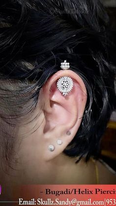 a woman with black hair and piercings on her ear