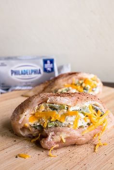 two sandwiches with cheese and broccoli are on a cutting board next to an ice pack