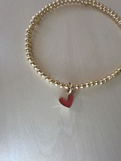 This 14kt gold filled bracelet is sure to be the perfect addition to your stack.  4mm beads are strung on durable elastic string with letter of your choice. Please measure wrist and add .5" for comfort.  This listing is for one bracelet. Happy Stacking! Dainty Heart Charm Bracelet With Round Beads, Everyday Heart-shaped Jewelry With Tiny Beads, Gold Charm Bracelet With Heart Beads For Valentine's Day, Gold Beaded Heart Bracelet For Valentine's Day, Adjustable Gold Heart Bracelet With Tiny Beads, Gold Heart Bracelet With Tiny Beads For Gift, Gold Heart Bracelet With Tiny Beads As Gift, Gold Heart Beads Bracelet, Dainty Everyday Beaded Bracelets With Heart Charm