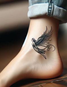 a woman's foot with a bird tattoo on the top and bottom part of her leg