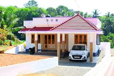 a small white car parked in front of a pink and white house with red roof