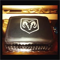 a black cake with white rams logo on it sitting on top of a wooden table