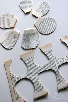 several pieces of paper cut out to look like scissors and book pages with holes in them