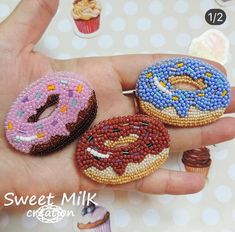 three beaded doughnuts are sitting on someone's hand and they look like they have been made out of beads