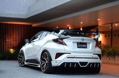 a white sports car parked in front of a building